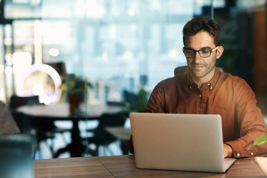 Businessman using a laptop while working late in his office